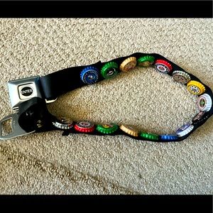 Bottle cap seatbelt belt with bottle opener feature